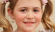 Smiling girl with pigtails and earrings.