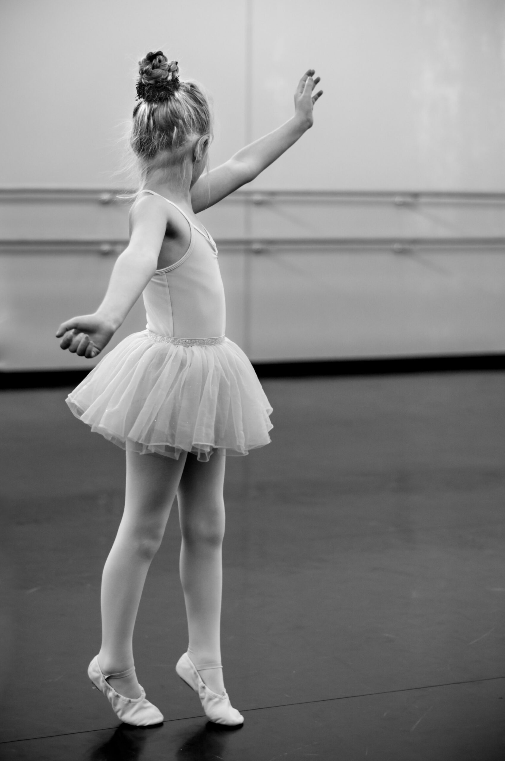 Young girl practicing ballet in a dance studio.